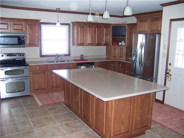 Red oak cabinets - Raised panel doors and drawer fronts - Full overlay style - Corian solid surface countertops